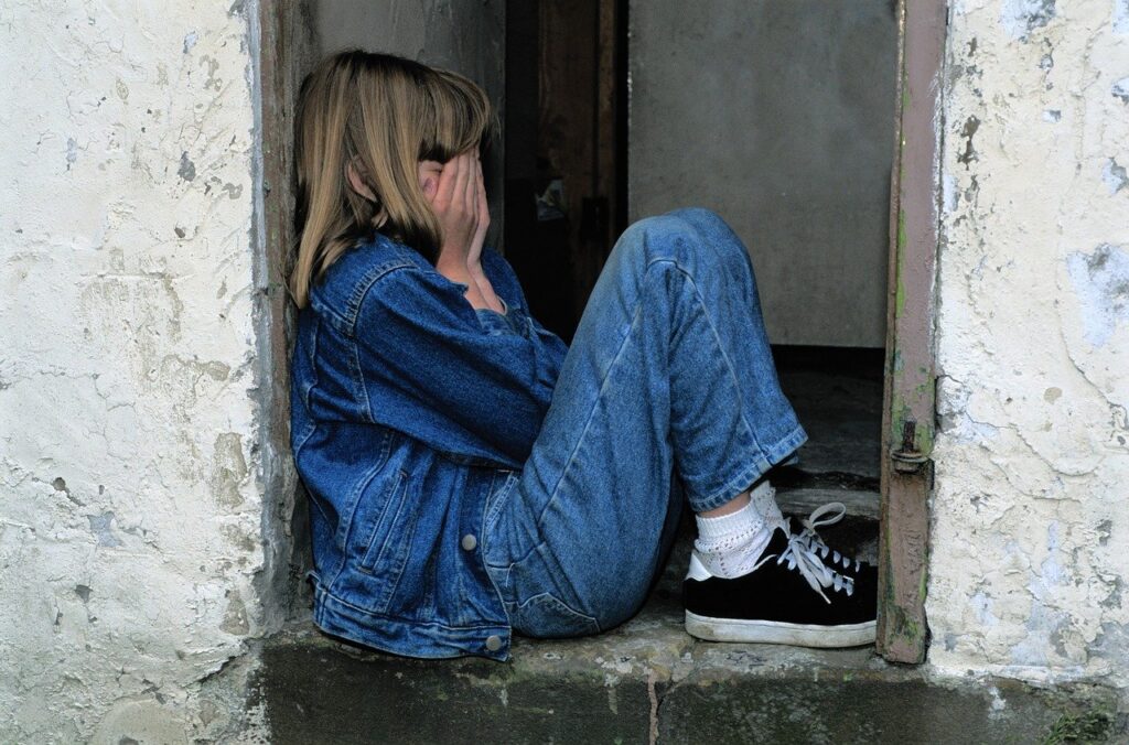 child sitting, jeans, in the door